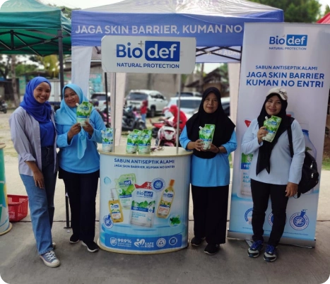 Mitra 2 Booth BioDef menampilkan produk sabun antiseptik di event Toko Yan, dengan tim promosi dan pengunjung berpartisipasi.